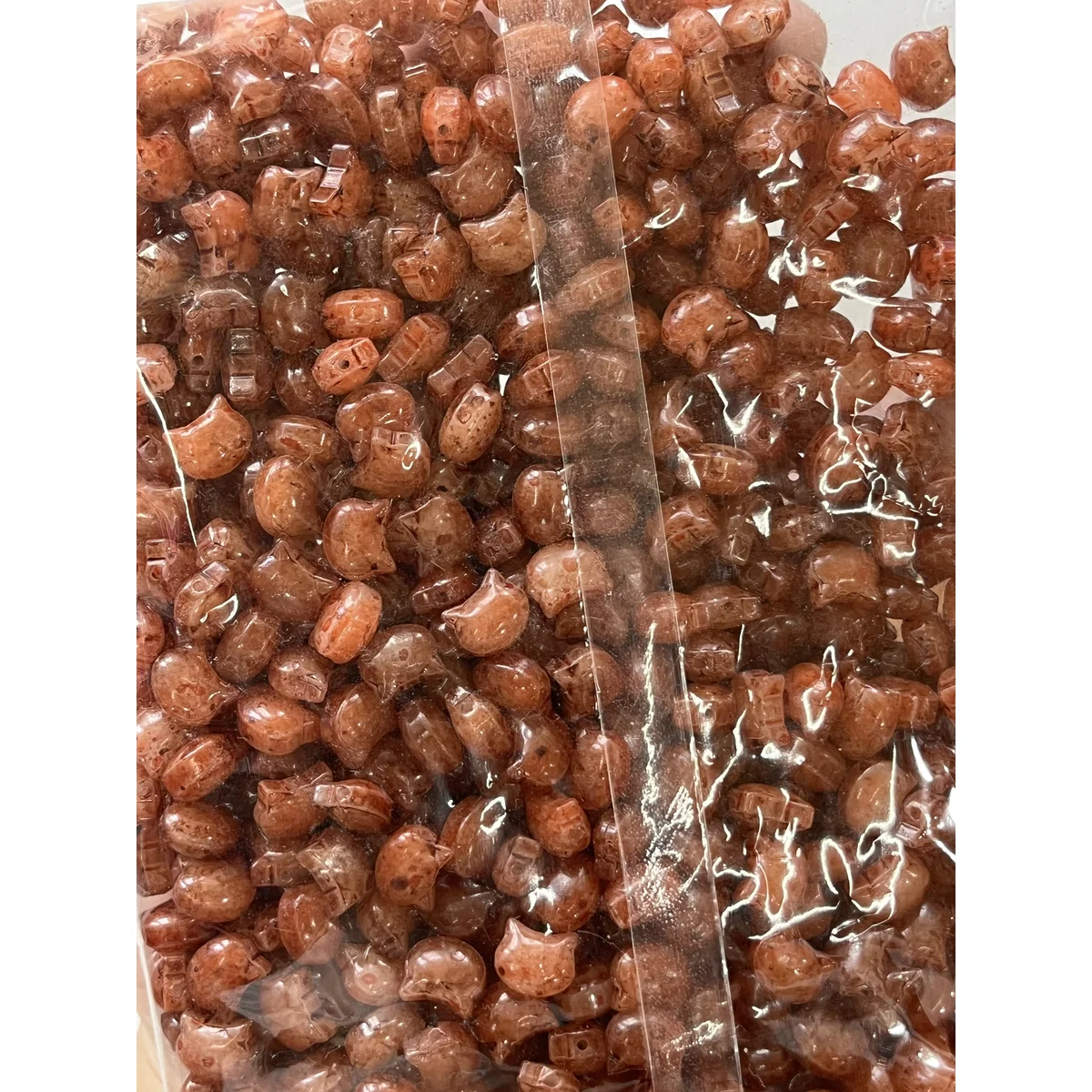 Orange Picasso-style glass cat-head beads in the photographed sales bag – 10 × 8 mm