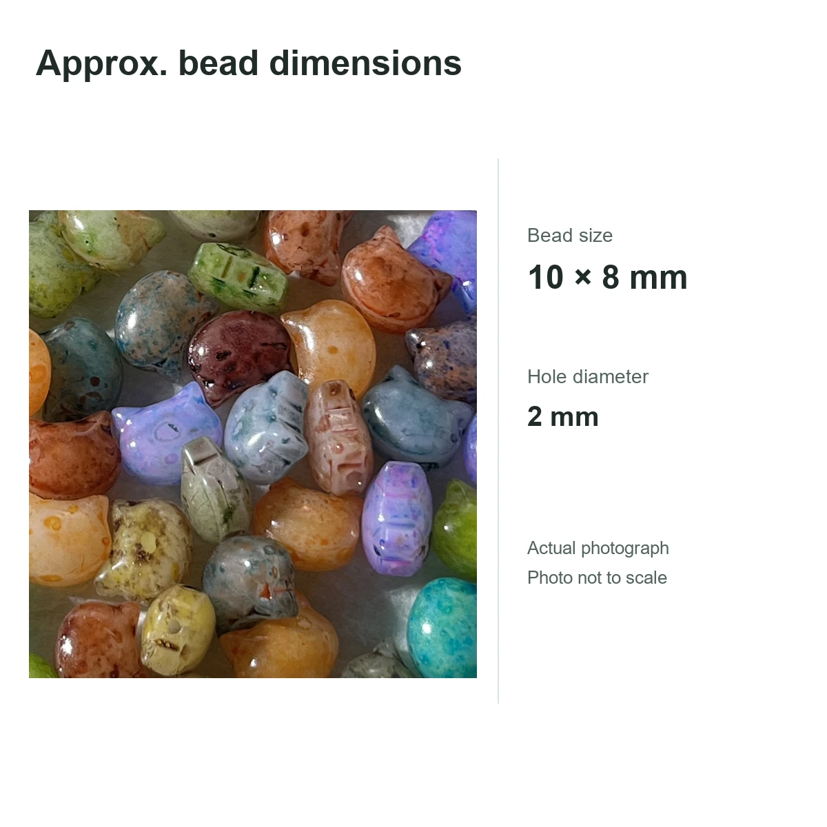 Photographie réelle de perles à tête de chat en verre de style Picasso à côté des dimensions approximatives de 10 × 8 mm ; photo pas à l'échelle