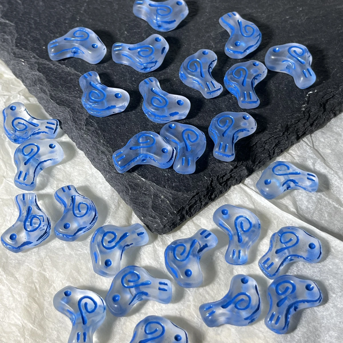 Blue translucent glass bird beads with colored spiral details