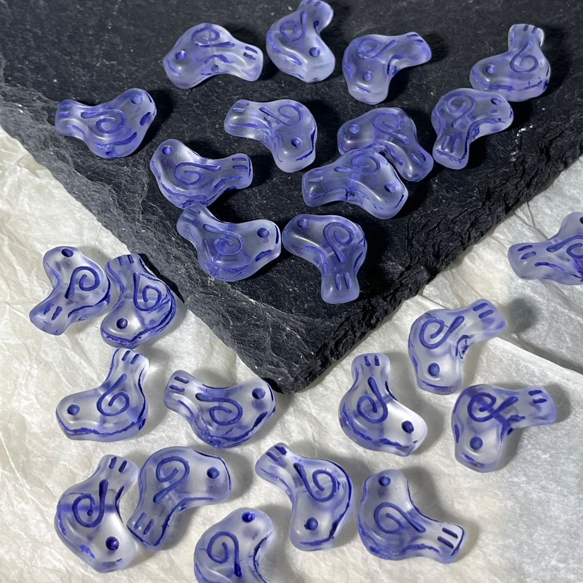 Purple translucent glass bird beads with colored spiral details